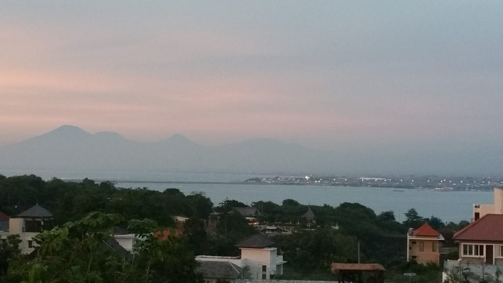 View over Jimbaran Bay from roof of Hotel Sintesa with mountains in background